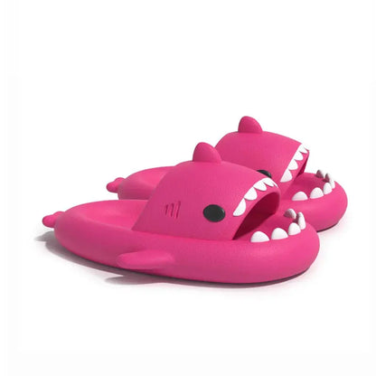 The CozySteps Unisex Shark-Pattern EVA Flip-Flops by CozySteps.uk feature bright pink, anti-slip slides with cartoon shark designs, including open mouths, white teeth, black eyes, and side and back fins. Available in US sizes 6–12.